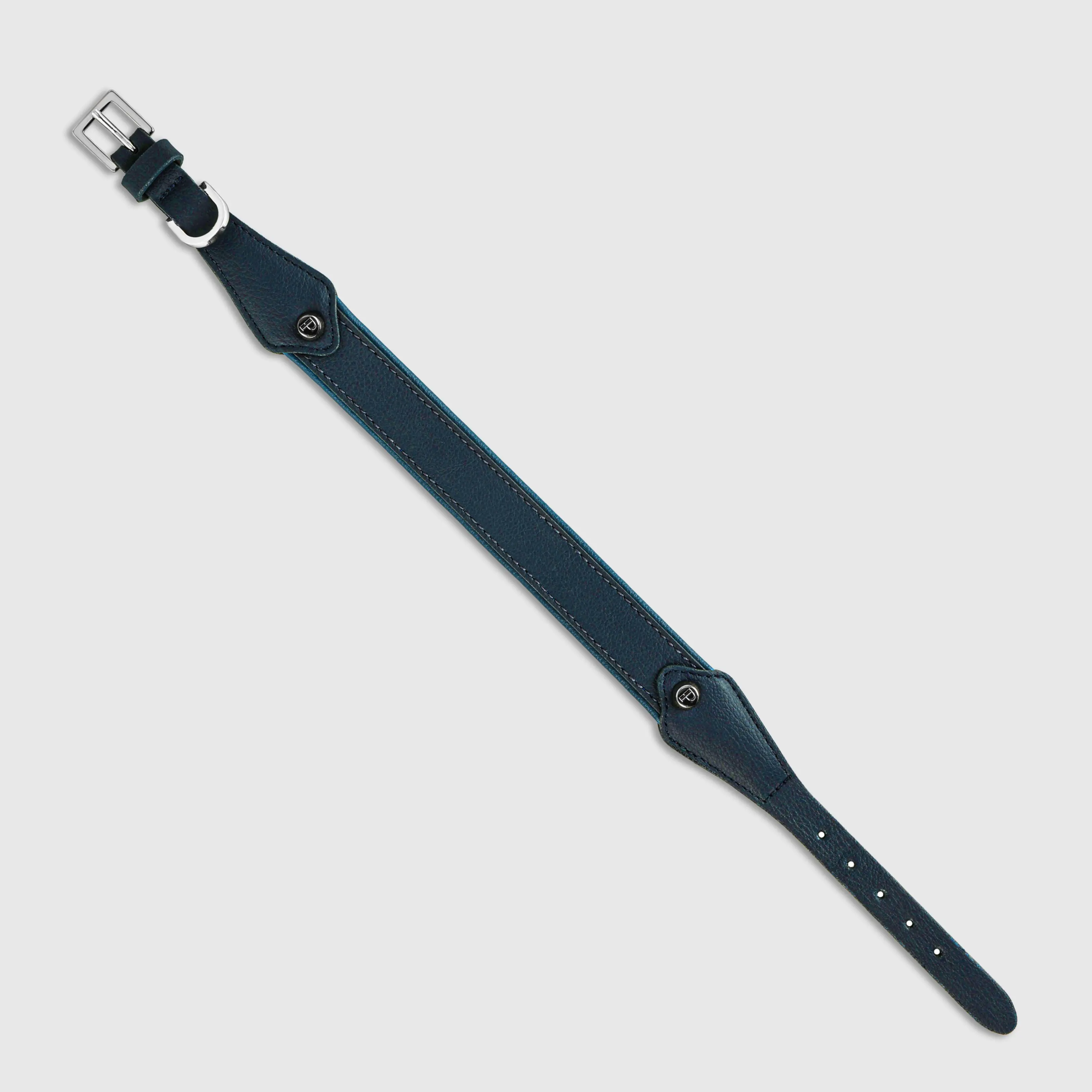 Hand-stitched from grained, cactus-based “leather” in an artisan workshop in the EU. Characterized by Pattmond’s signature shape, distinguished by subtle shifts in width and refined ornamental details. Navy exterior with matching navy stitching and a royal blue lining. Solid brass hardware in silver (D-ring for the leash, buckle and signature logo studs), nickel-free and protected with a durable, polished finish. Adjustable length (see dimensions to choose the best fit for your dog). Available individually or in a set with a matching cactus-based “leather” leash.