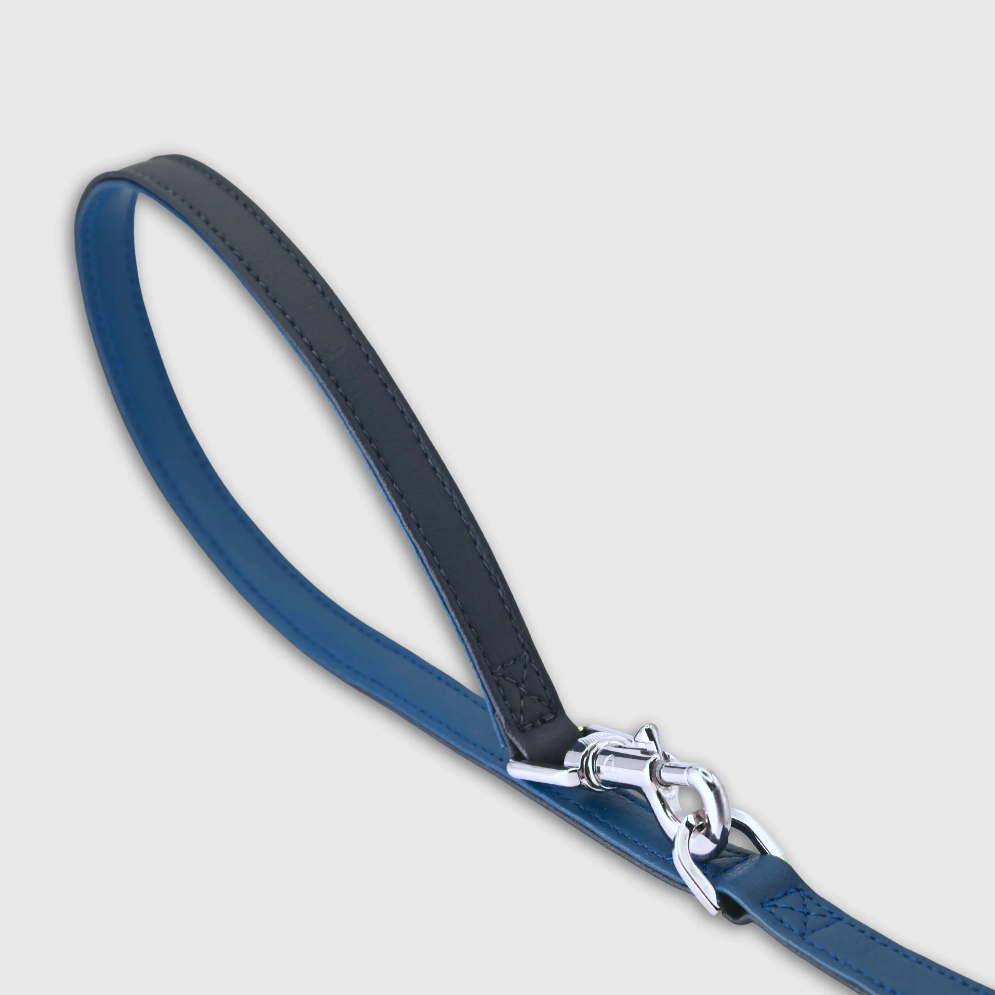 Hand-stitched from grained, cactus vegan leather in an artisan workshop in the EU. Characterized by Pattmond’s signature shape, distinguished by subtle shifts in width and refined ornamental details. Navy cactus-based leather with matching navy stitching. Solid brass hardware in silver (signature snap hook and logo studs), nickel-free and protected with a durable, polished finish. Adjustable length of 230 cm, 150 cm, and 115 cm. With a width of 2.2 cm, it is proportioned for larger dogs.
